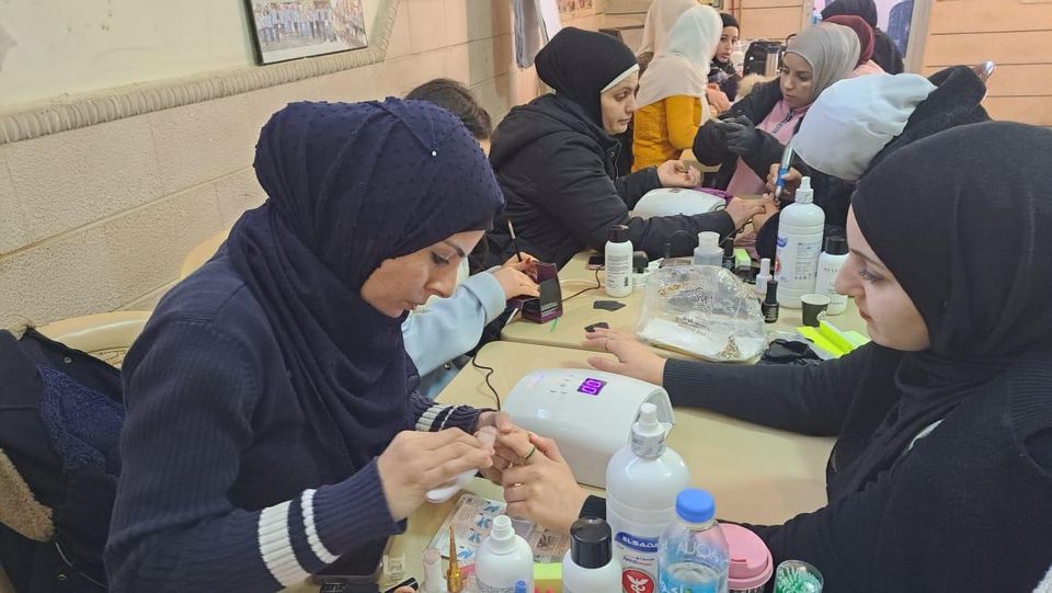 متدرّبات يعملن مع مصباح UV ومستلزمات العناية بالأظافر